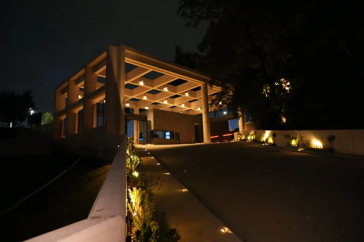 Acceso principal de noche — foto real